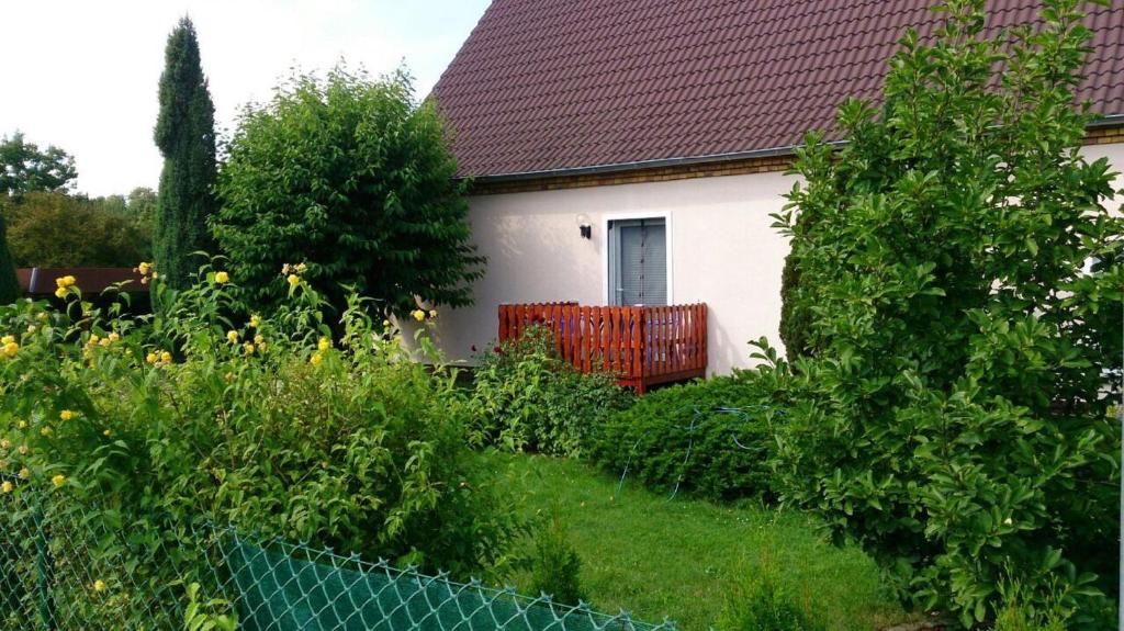 una casa blanca con una valla roja en un jardín en Ferienwohnung Branitz, en Cottbus