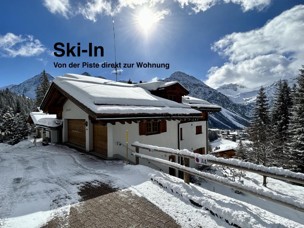 una casa cubierta de nieve con las palabras "esquiar" en Höhwald - Maranerhang en Arosa