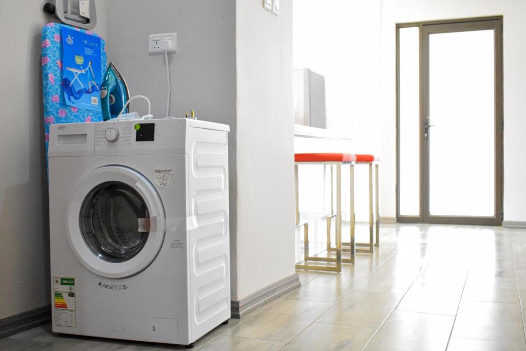 a washing machine in a room with a kitchen at Forefront Self-Catering Apartments in Kitwe