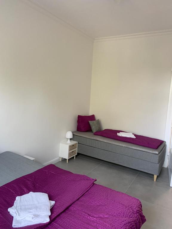 sypialnia z 2 łóżkami i fioletową pościelą w obiekcie Villa Mariensiel w mieście Sande
