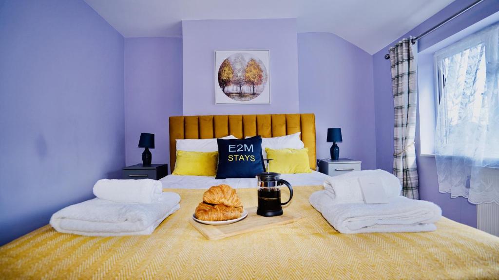 una camera da letto con un letto e due asciugamani di E2M Stays Beautiful House Close To Heathrow Airport- Walking Distance To Thames River a Egham