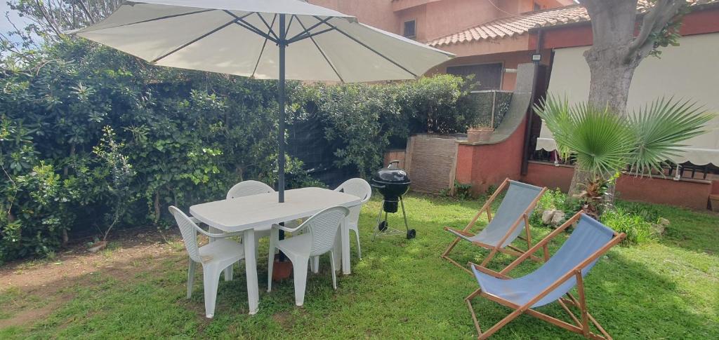 una mesa y sillas con una sombrilla en un patio en Casa vacanze marina di san nicola, en Palo