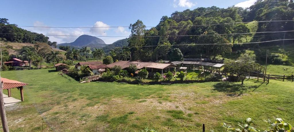 a house in a field with mountains in the background at Solo Sagrado in Bom Jardim