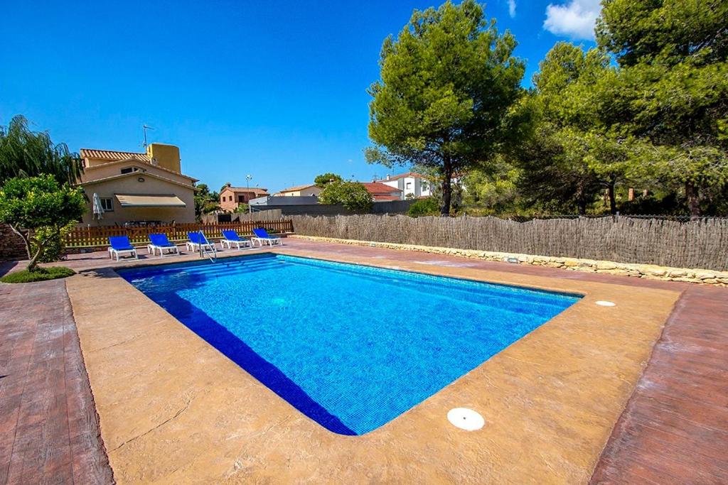 una piscina azul con sillas y una casa en Catalunya Casas Magical Costa Dorada Decadence only 2km to beach!, en Roda de Bará
