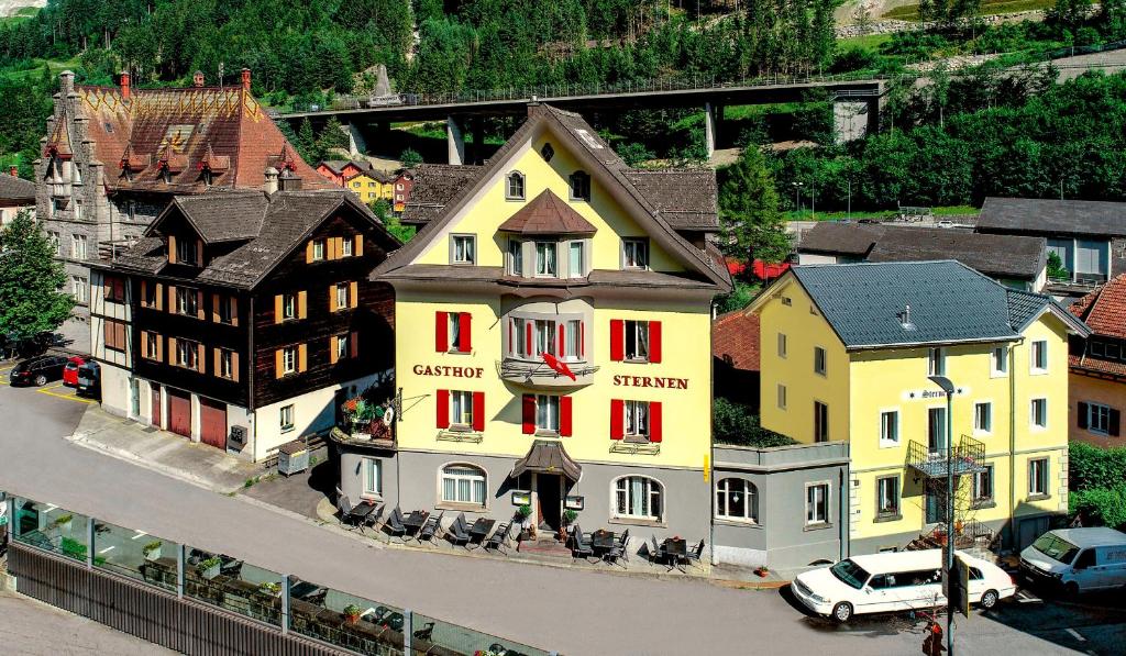 un bâtiment jaune avec des fenêtres rouges dans une ville dans l'établissement Hotel Sternen, à Gurtnellen