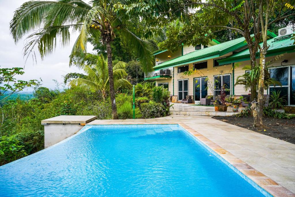 a swimming pool in front of a house at Jungle Jewel in Quepos