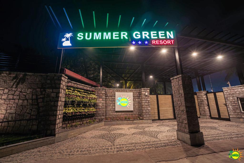 a sign for a summer green restaurant at night at SUMMER GREEN RESORT in Secunderabad