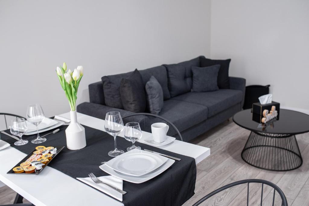 sala de estar con sofá, mesa y sillas en TEILOR Apartments 5, en Floreşti
