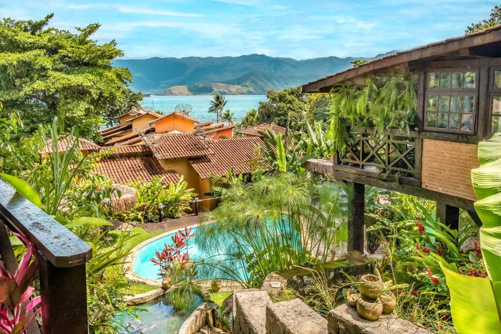 een afbeelding van een tuin met een zwembad en een huis bij Cantinho Alentejano in Ilhabela