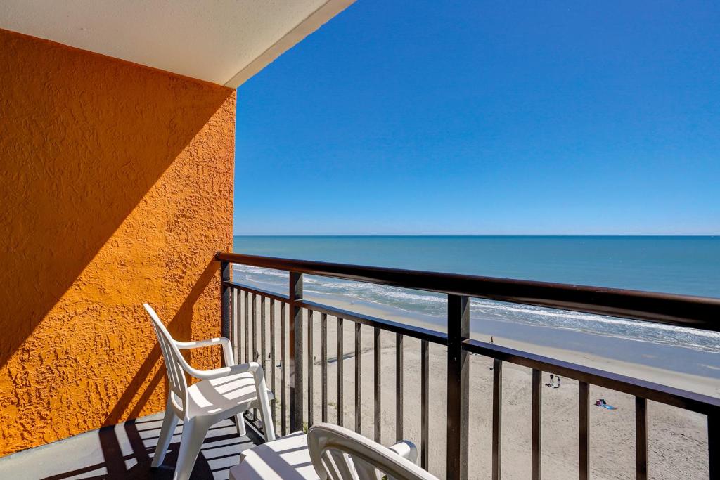 a balcony with two chairs and the ocean at Landmark Resort 936 in Myrtle Beach