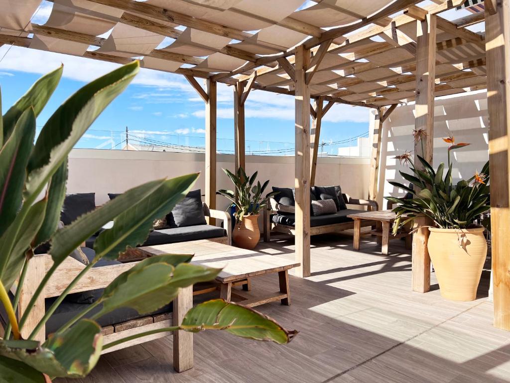 un patio avec des canapés et des plantes sur le toit dans l'établissement Valencia Luxury - Calma Beach Apartments, à Valence