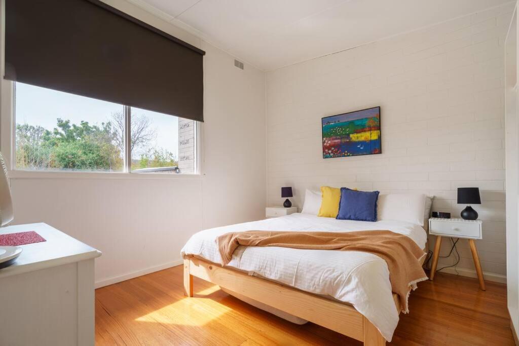 um quarto com uma cama grande num quarto branco em Argo Sands em Rosebud