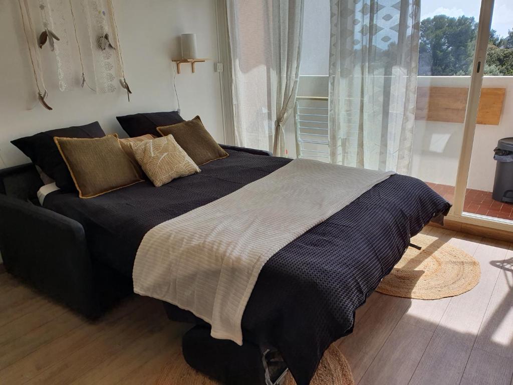 Joli Studio cavalaire في كافالير سور مير: سرير كبير في غرفة نوم مع نافذة