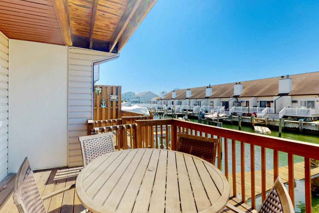 a wooden deck with a table and chairs on a balcony at The Coral Starfish #10J in Ocean City