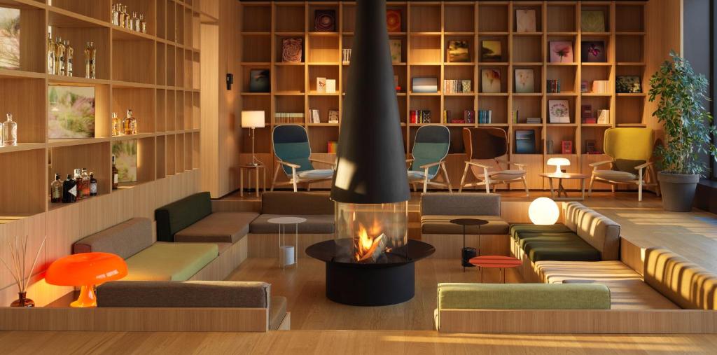 una sala de estar con chimenea en una biblioteca en Le Fucine Hotel, en Buttrio