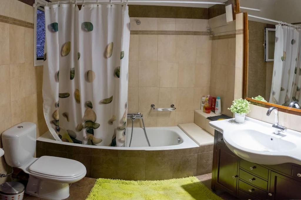a bathroom with a tub and a toilet and a sink at Villa Archontia Family House!!! in Preveza