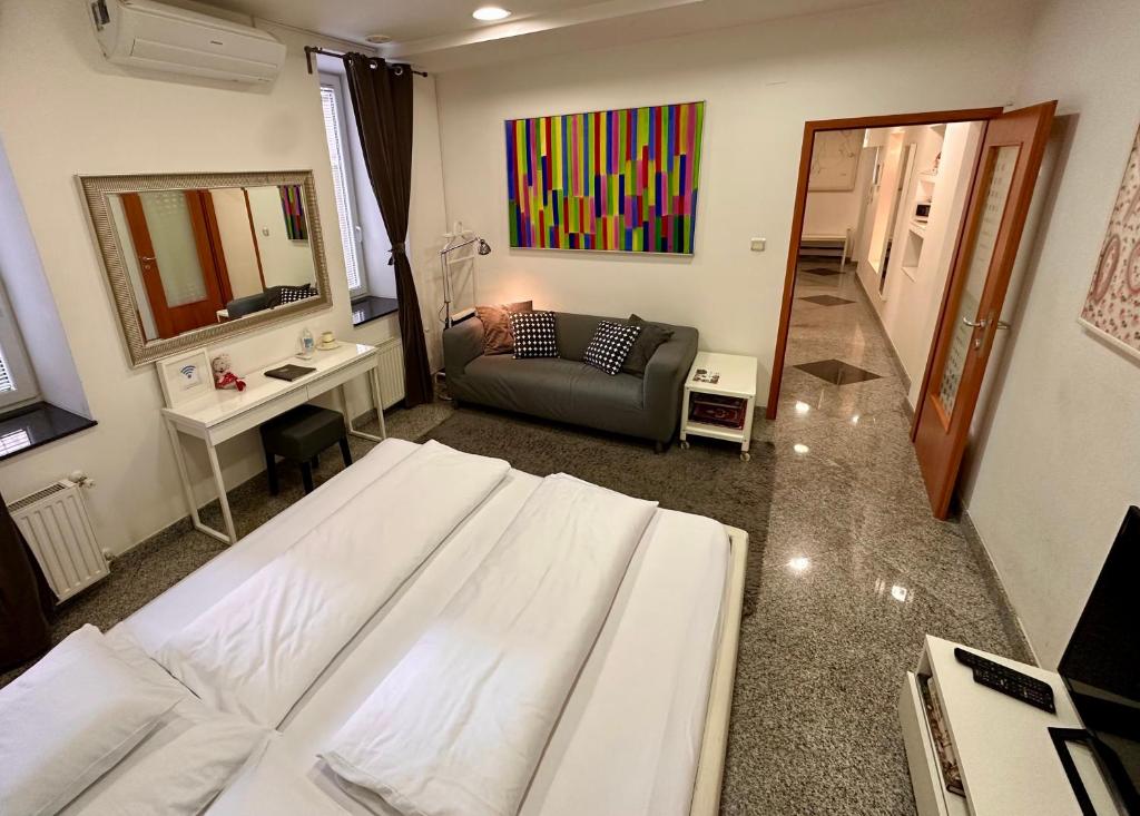 - une chambre avec un grand lit blanc et un canapé dans l'établissement Smart Apartment, à Zagreb