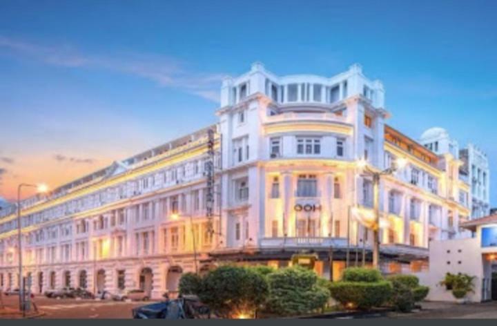 un grand bâtiment blanc situé dans un parking dans l'établissement Grand Oriental Hotel, à Colombo
