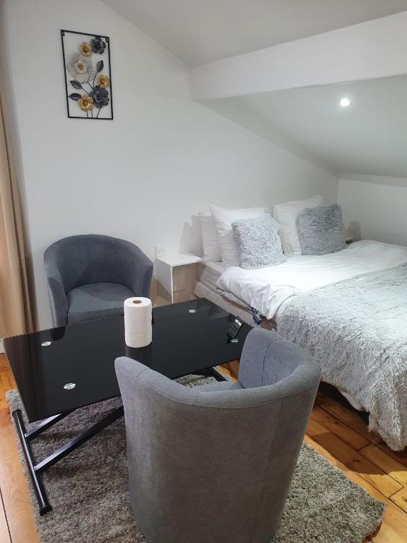 une chambre avec un lit et deux chaises et un bureau dans l'établissement Studio pratique CDG/Villepinte/ le Bourget, à Aulnay-sous-Bois
