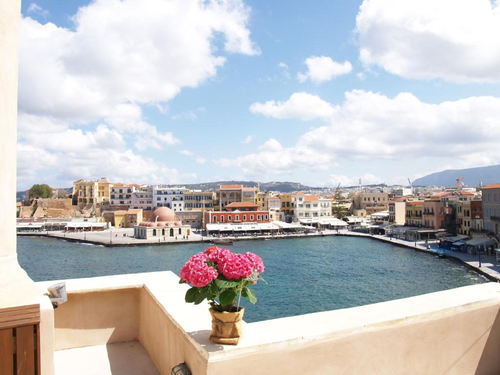 een vaas met bloemen op een balkon met uitzicht op de stad bij Hotel Amphora in Chania