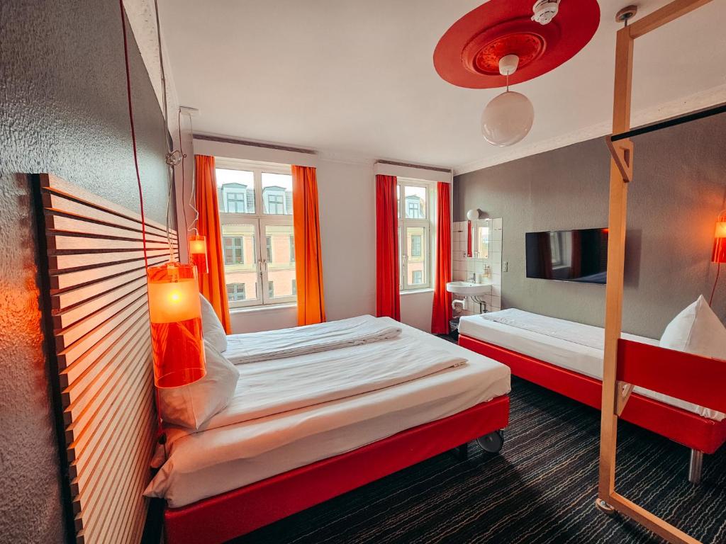 a hotel room with two beds and a tv at Annex Copenhagen in Copenhagen