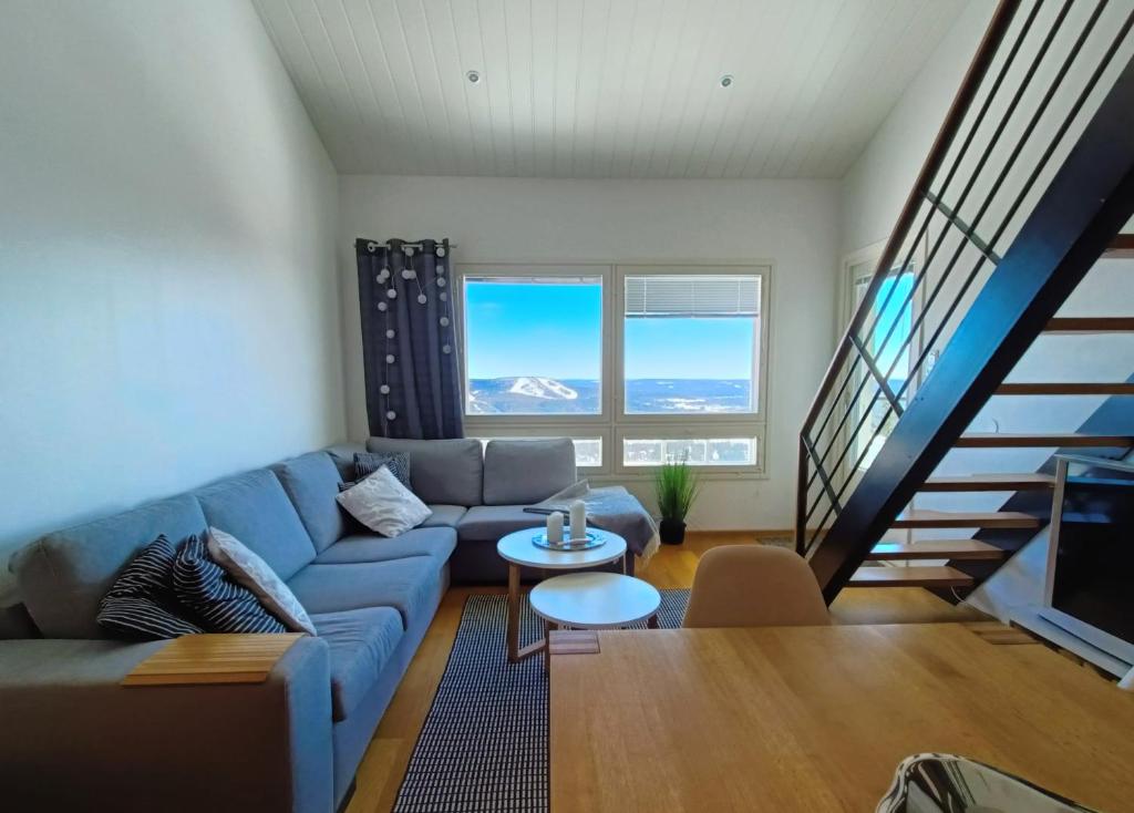 Una sala de estar con un sofá y una escalera. en The Peak House, en Syöte