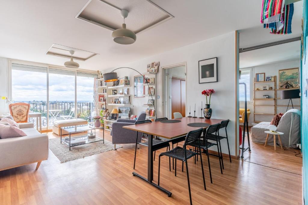 a dining room and living room with a table and chairs at La Dolce Vita - vue sur la Garonne in Cenon