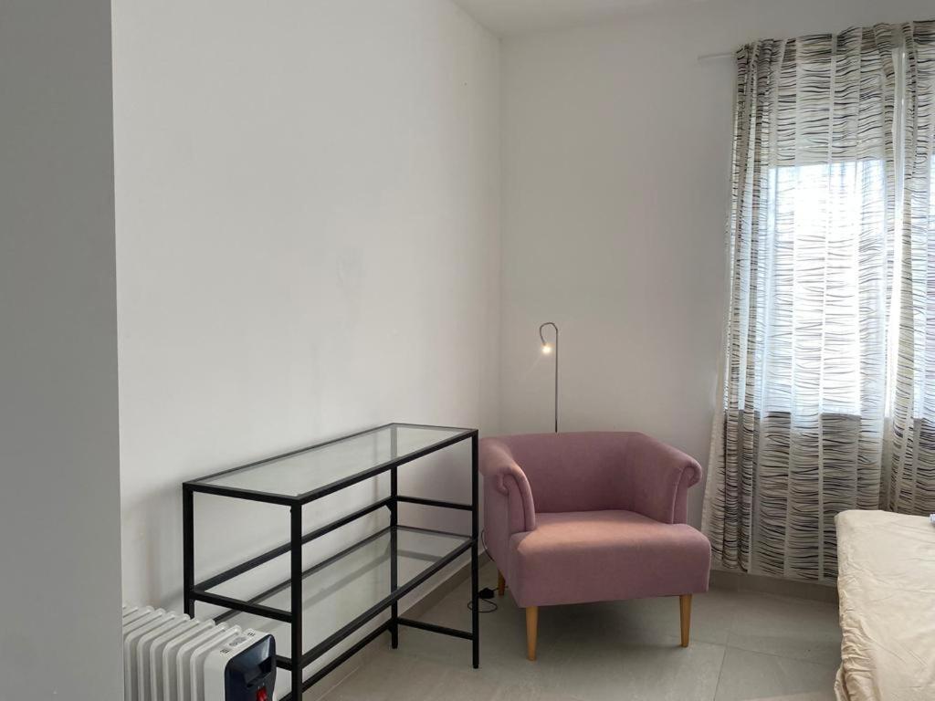 ein Wohnzimmer mit einem Stuhl und einem Glasregal in der Unterkunft Apartment Olive in Medulin