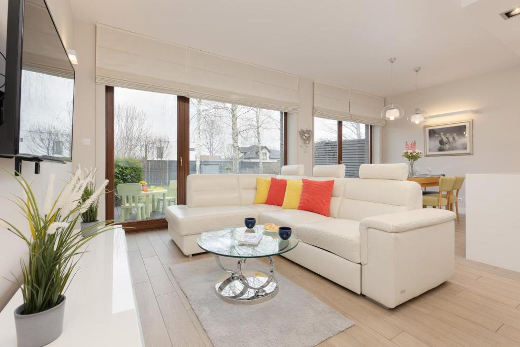 a living room with a white couch and a table at Three-Bedroom Family House with Garden Warsaw Nowa Wieś by Renters in Warsaw