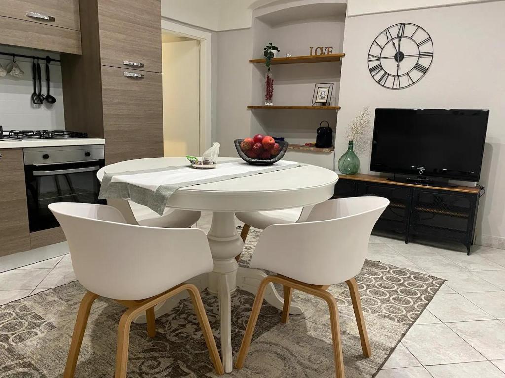 a white table and chairs in a kitchen with a tv at Rossi21 in Cuneo