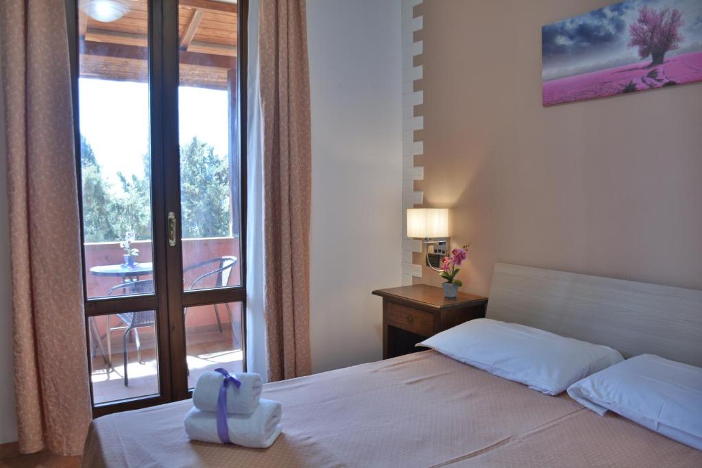 a bedroom with a bed and a door to a balcony at Hotel Villa Paradiso in Riparbella
