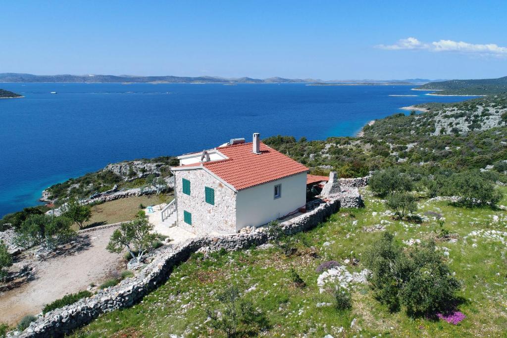 an island with a house on a hill with water at House Lovre in Tkon