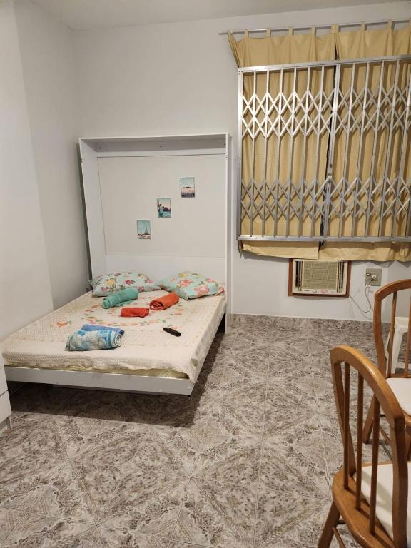 um quarto com uma cama, uma mesa e cadeiras em Conjugado bem localizado em Copacabana no Rio de Janeiro