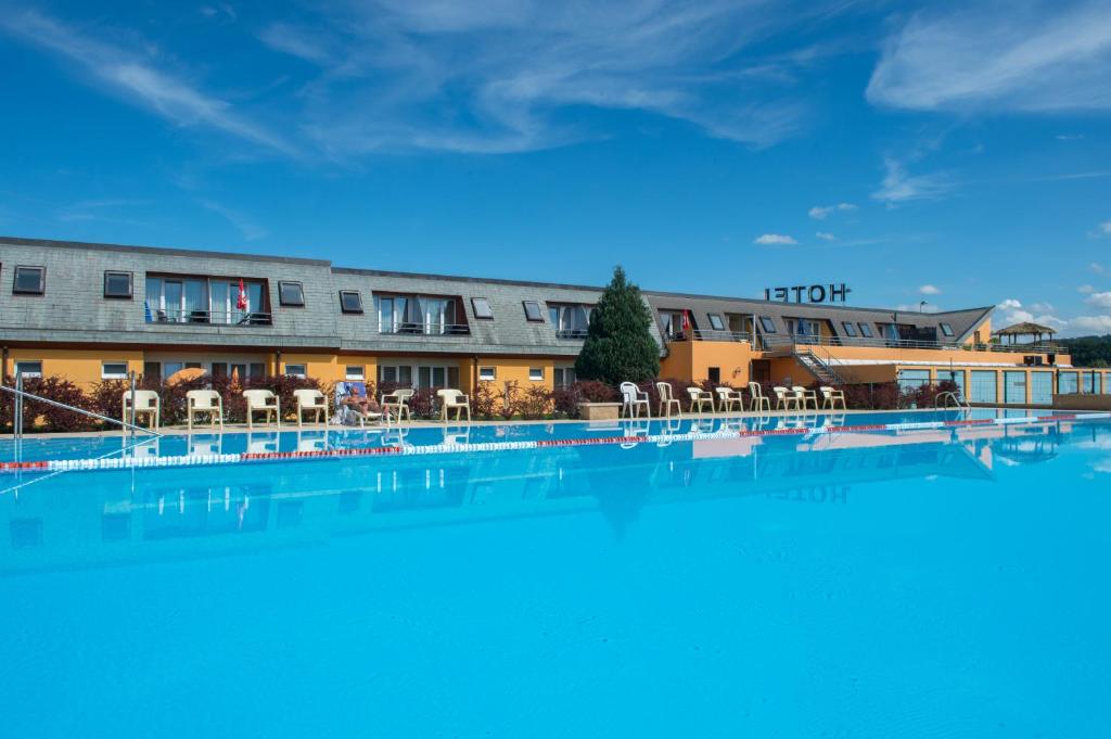 una gran piscina frente a un hotel en Hotel Lacotel, en Avenches