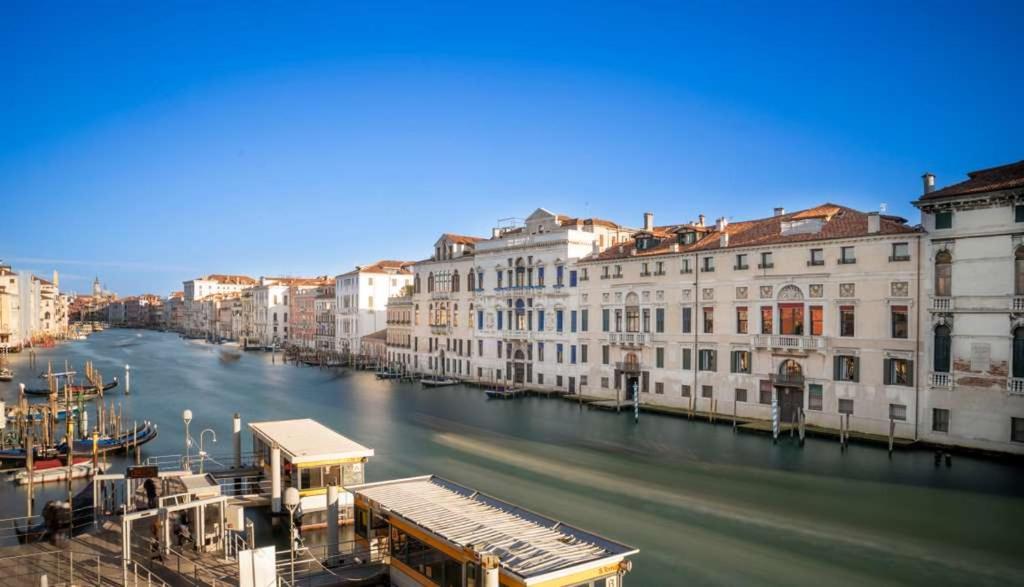 Blick auf einen Fluss in einer Stadt mit Gebäuden in der Unterkunft Mocenigo Grand Canal Luxury Suites in Venedig