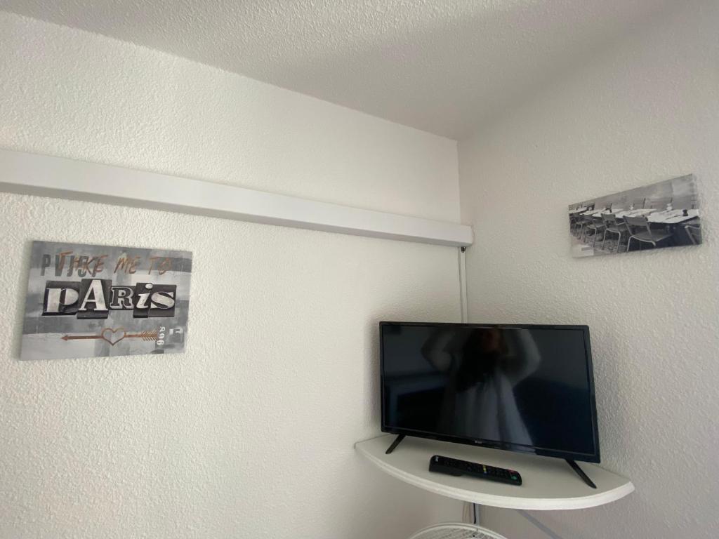 TV de pantalla plana en la pared de una habitación en Joli T2 Centre port résidence Quai d'Honneur, en Cap d'Agde