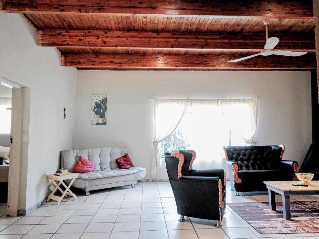 een woonkamer met 2 banken en een plafond bij Zulia home in Pretoria