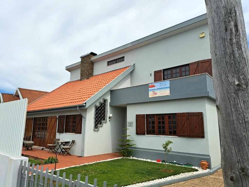 a white house with an orange roof at Beachwalk guesthouse in Esmoriz