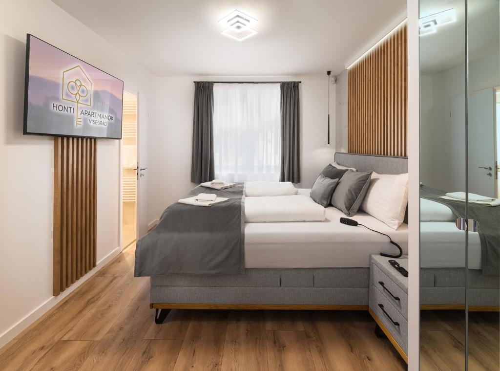 um quarto com uma cama grande e uma televisão em Szikla apartmanok Visegrád em Visegrád