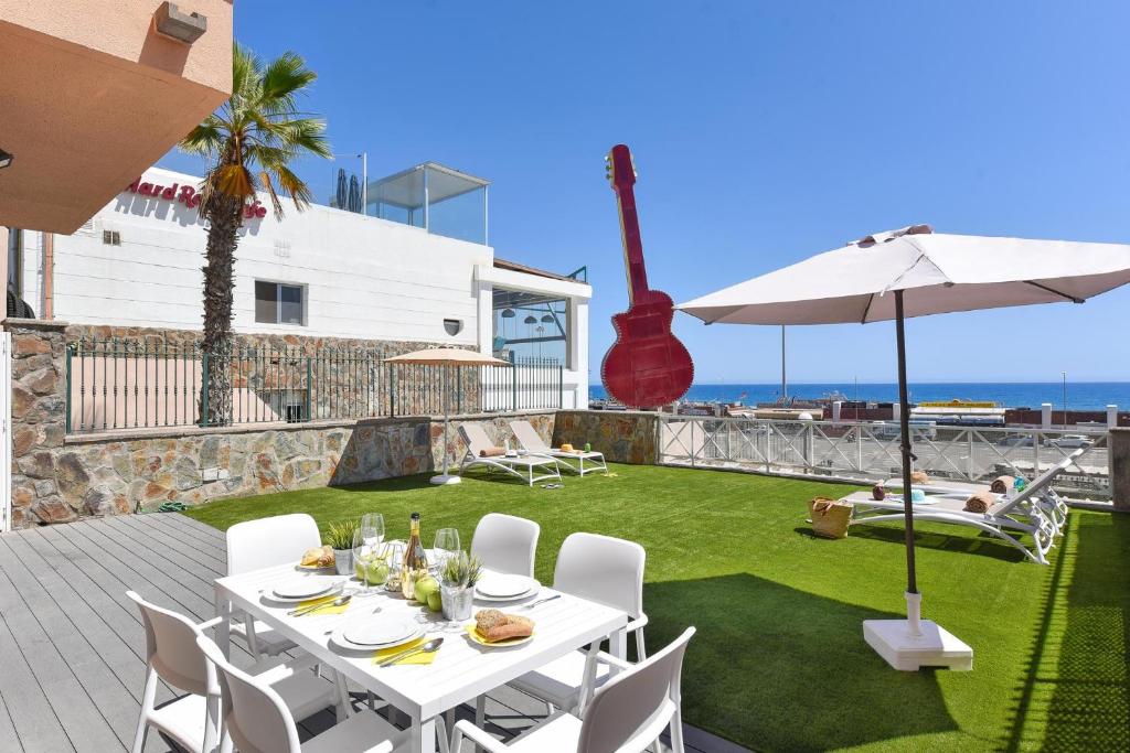 a patio with a table and chairs and an umbrella at Chalet Santa Ana 25 by VillaGranCanaria in Playa del Ingles