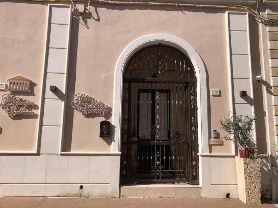 un edificio con una gran puerta negra con un arco en Glem beauty, en Copertino