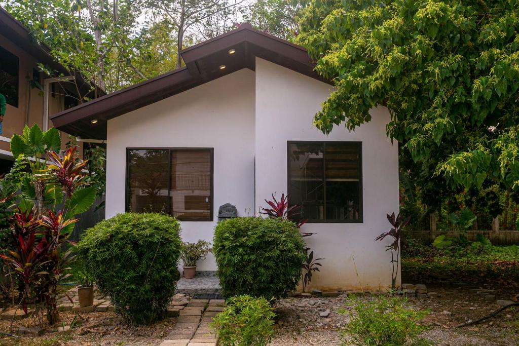 una casa blanca con plantas delante en Casa Amanda bungalow with hi-speed internet en Corón