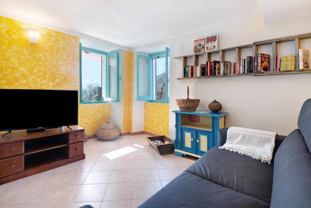 ein Wohnzimmer mit einem Sofa und einem Flachbild-TV in der Unterkunft La Fermenteria in San Colombano Certenoli