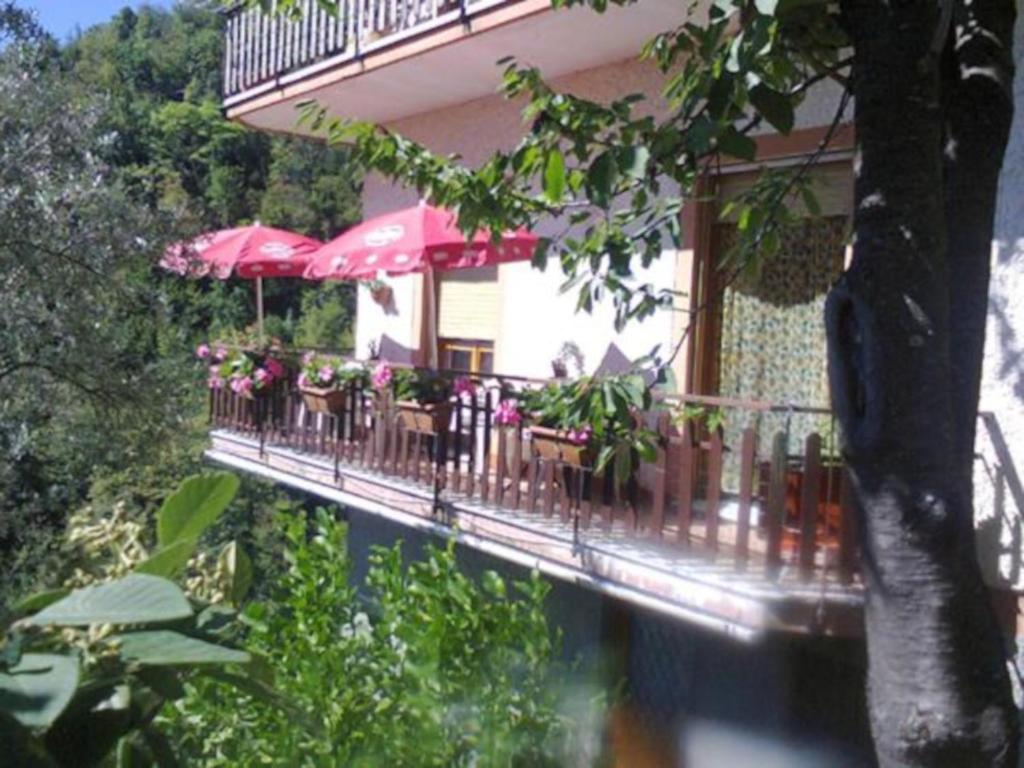 einen Balkon mit Tischen und Sonnenschirmen auf einem Gebäude in der Unterkunft La Margherita di Teriasca in Teriasca