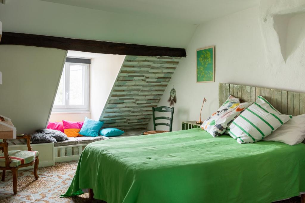 a bedroom with a green bed and a couch at Atipyk'ododo in Saint-James