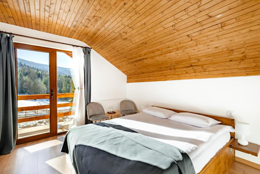 1 dormitorio con cama y ventana grande en Casa din Munți Vlădeasa, en Rogojel