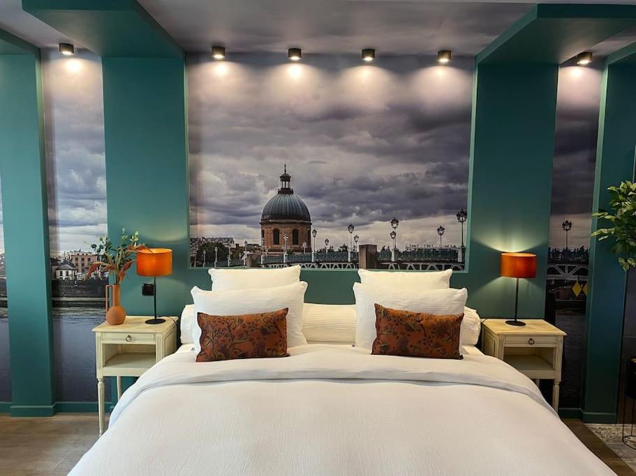 - une chambre avec un grand lit et une photo d'un bâtiment dans l'établissement Suite Garonne - baignoire balnéo duo à bulles - Luxe et charme - climatisation, à Eyrans-de Soudiac