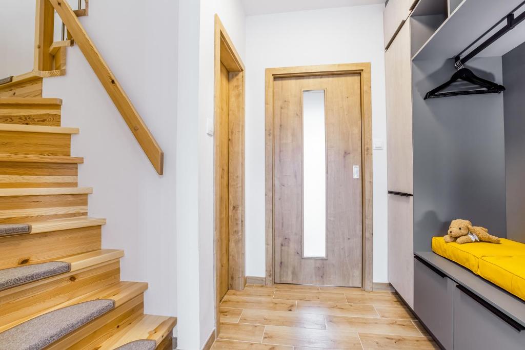 a hallway with a yellow bed and a door at Apartmány Karlovy Dvory in Horní Planá