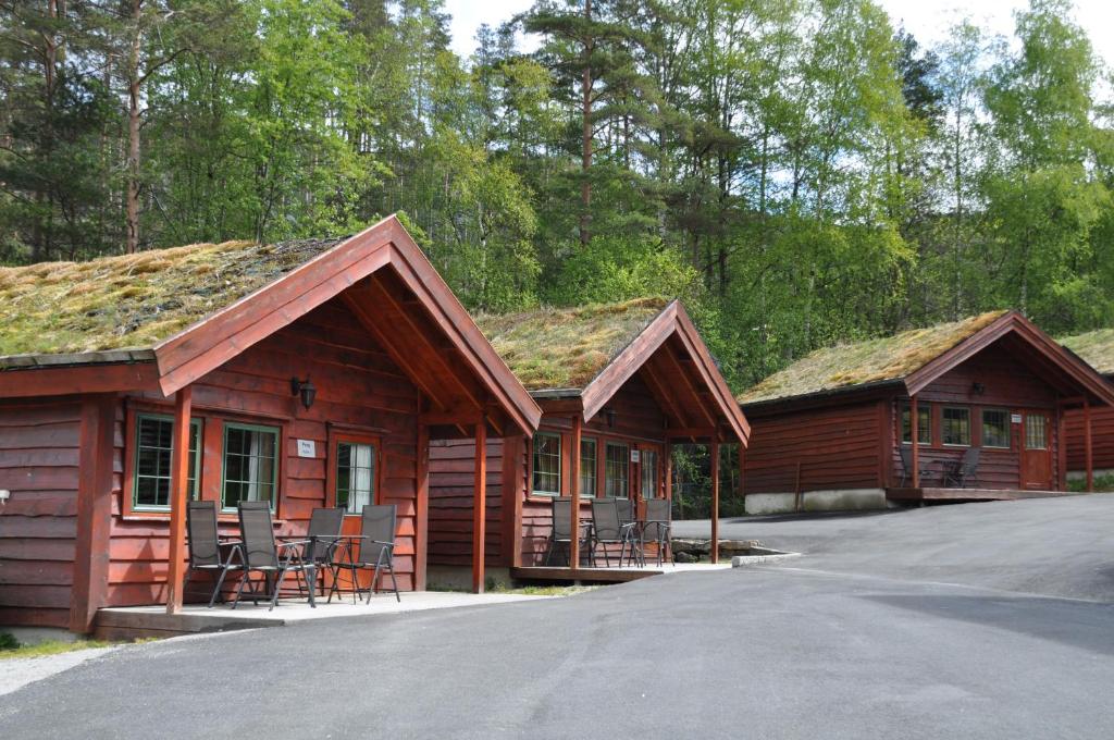 a couple of log cabins with chairs in front of them at Tonstadli in Tonstad