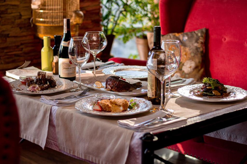 una mesa cubierta con platos de comida y copas de vino en Boutique Spa Casino Hotel Lybid Plaza en Khmelʼnytsʼkyy